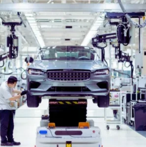 Automobile industry factory with technicians working on a car in an advanced assembly line, showcasing modern vehicle manufacturing.