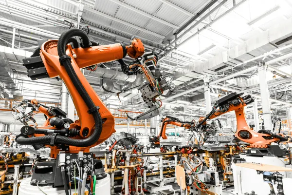 Automobile industry assembly line with robotic machinery performing complex manufacturing tasks.