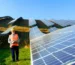 Engineer inspecting large solar panel installation, reflecting photovoltaic industry advancements in renewable energy